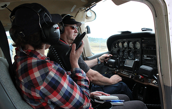 Kaksi lentäjää koneen ohjaamossa, Virve-puhelin myös käytössä.