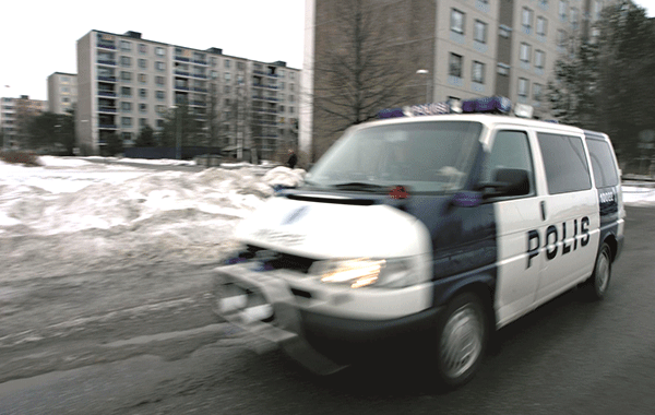 Poliisiauto ajaa loskaisessa talvimaisemassa lähiön kaduilla.