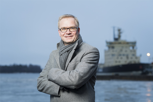 Erillisverkkojen toimitusjohtaja Timo Lehtimäki seisoo merenrannassa taustallaan laiturissa olevat jäänmurtajat.