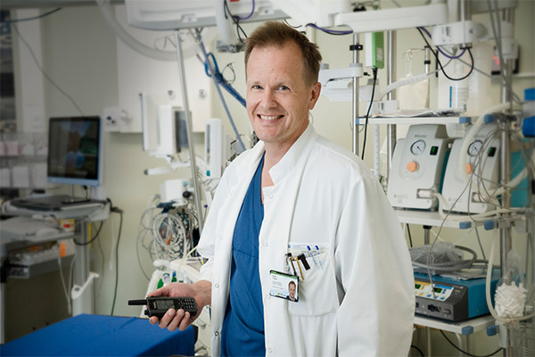 Kainuun keskussairaalan ylilääkäri Tuomo Erola sairaalatiloissa kädessään Virve-puhelin. 