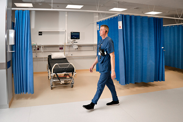 Sairaanhoitaja Marko Huuskonen kävelee Kainuun keskussairaalan käytävällä.