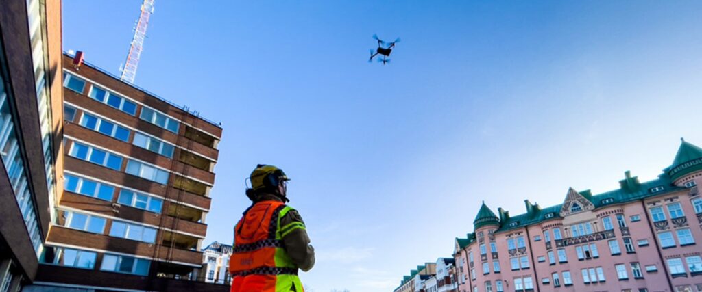 Viranomainen lennättää dronea taivaalla.